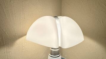 A corner lamp with a white shade on a tiled floor.