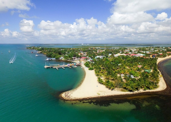 Une vue aérienne d’une zone côtière avec une plage, une jetée et une petite ville.