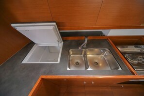A compact kitchen with a built-in sink, a countertop, and wooden cabinets.