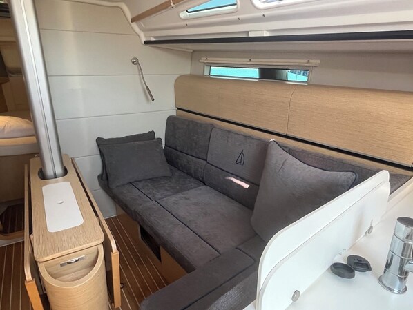 Et kompakt, moderne interiør med en sofa, et lille bord og et vindue.