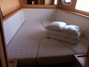 A small, single-bed room with a wooden headboard and a window.