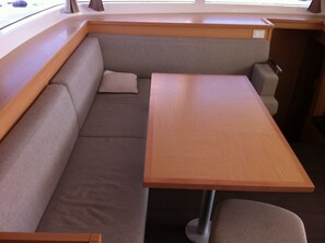A compact, modern interior with a bench seating area, a wooden table, and a window providing natural light.