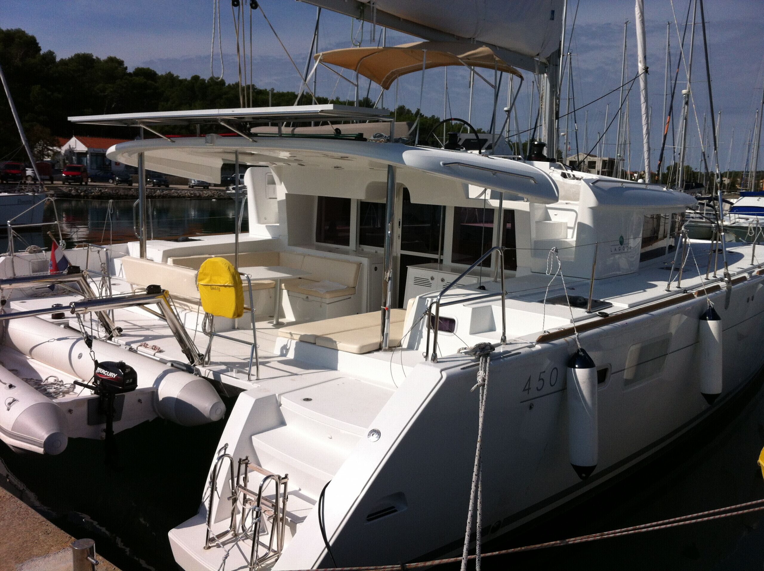 A white yacht with a covered deck area, a seating arrangement, and a number '450' on the side.