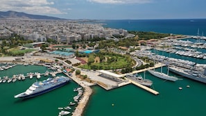 A marina with multiple boats, a large cruise ship docked, and a cityscape in the background. - Sun-Kissed Sailing Adventure in the Saronic Islands (Kallithea)