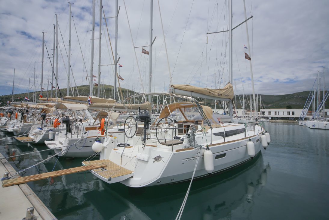 En lysthavn med flere sejlbåde i havnen, med master, sejl og redningskranse.