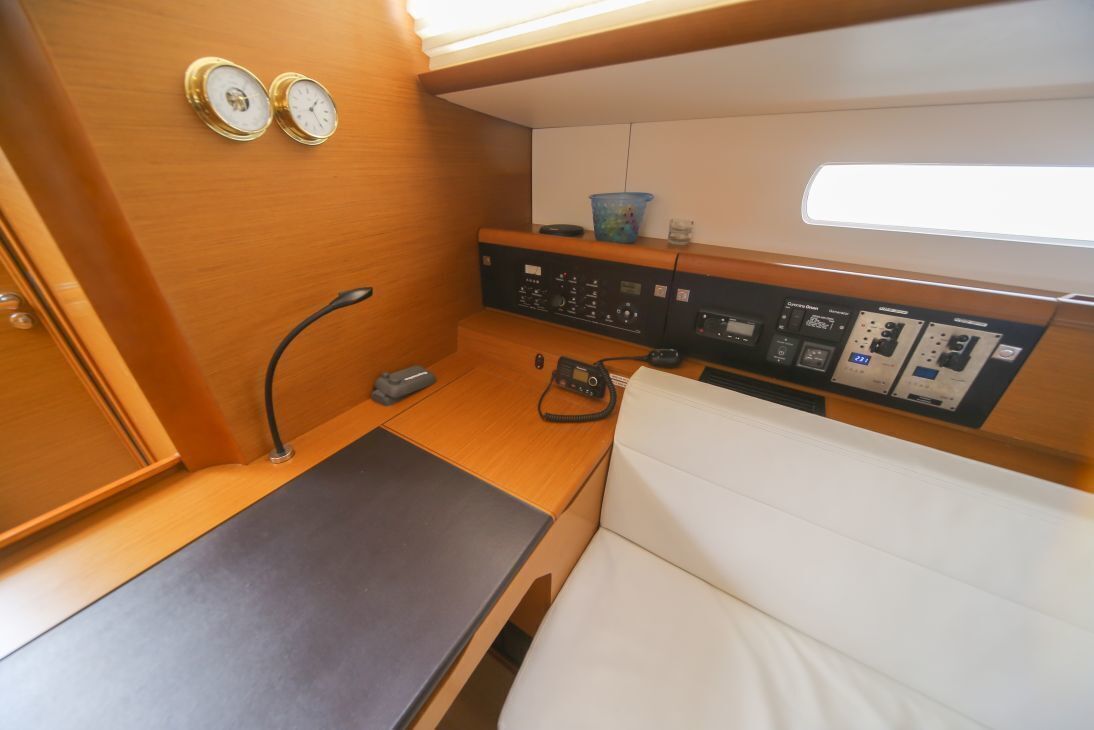 A compact control panel with various switches and dials, a small table, and a white cushioned seat.