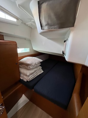 A compact cabin with a bunk bed, a small window, and a storage cabinet. - Sun-Kissed Sailing Adventure in Zadar, Croatia (Bibinje)