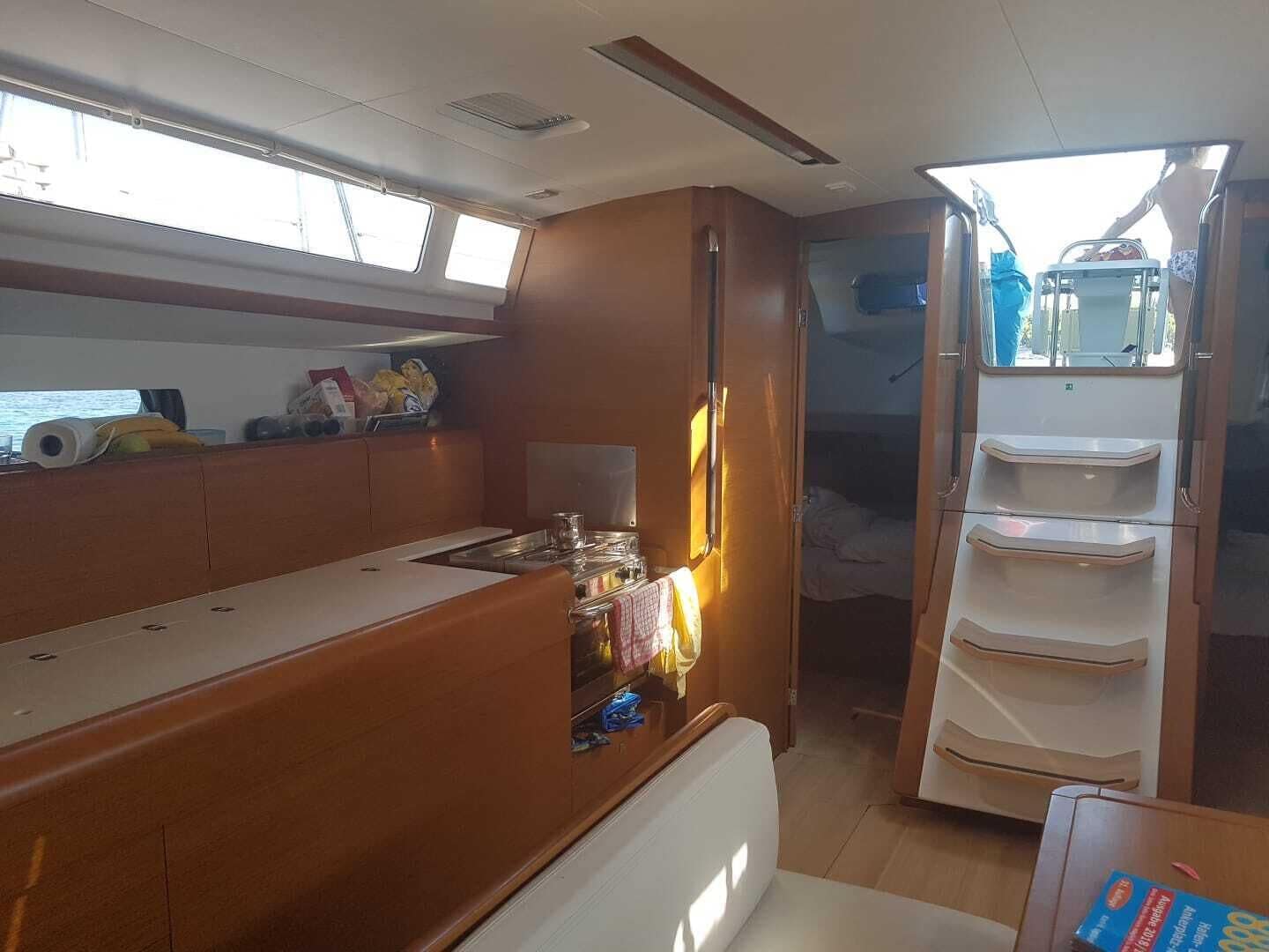 A compact kitchen with a stove, sink, and storage shelves.