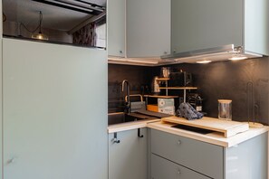 A modern kitchen with grey cabinets, a wooden countertop, and a built-in oven. - Les Cimes d'Hestia - Proche station de ski (La Salle-les-Alpes)