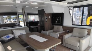A compact interior with a dining area, sofa, and kitchenette. - Sun-Kissed Sailing Adventure in Provence-Alpes-Côte d'Azur (Hyères)