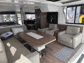A compact interior with a dining area, sofa, and kitchenette.