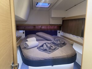 A bunk bed with a skylight, a bedside table, and a headboard. - Sun-Kissed Sailing Adventure in the Ionian Islands, Lefkada (Lefkada)