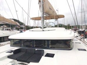 A yacht with a covered deck area, a seating arrangement, and a sail.