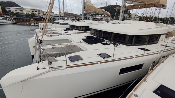 A marina with multiple yachts docked, featuring open deck areas and seating arrangements.