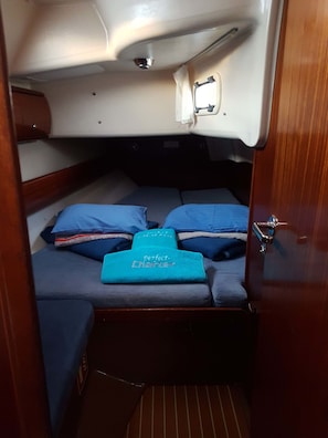 Une petite cabine équipée d’un lit superposé, d’une petite fenêtre et d’une porte.