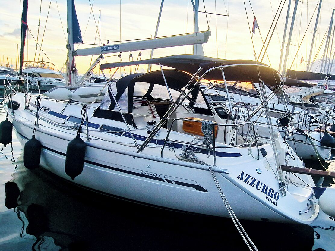 A sailboat named 'BAVARIA 41' docked at a marina with other boats.