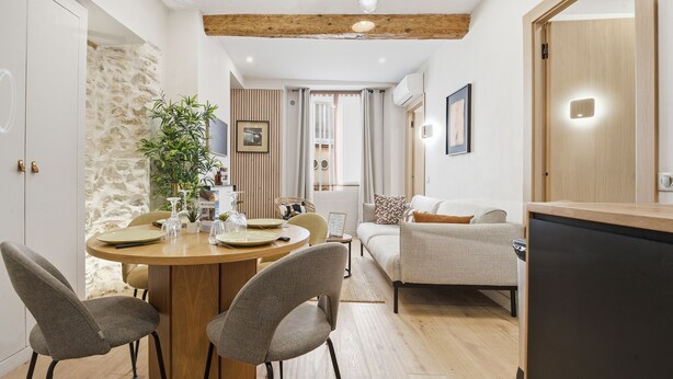 Una cucina moderna con un tavolo da pranzo, sedie e un frigorifero.