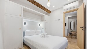 Una camera da letto moderna con un letto, un armadio a muro e una trave in legno al soffitto.