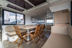 A modern interior with a dining area, cushioned seating, and a view of the marina. - Sun-Kissed Sailing Adventure in the Ionian Islands, Lefkada (Lefkada)