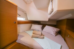 Ein gemütliches Blockhaus mit Bett, Kissen und einem ordentlich gefalteten Handtuch.