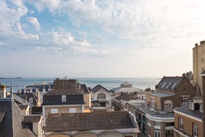 Eine Küstenstadt mit historischen Gebäuden, Blick aufs Meer und blauem Himmel.