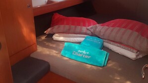 A compact bunk bed with a storage cabinet, a small seating area, and a window with a view. - Sun-Kissed Sailing Adventure in Northern Croatia (Punat)
