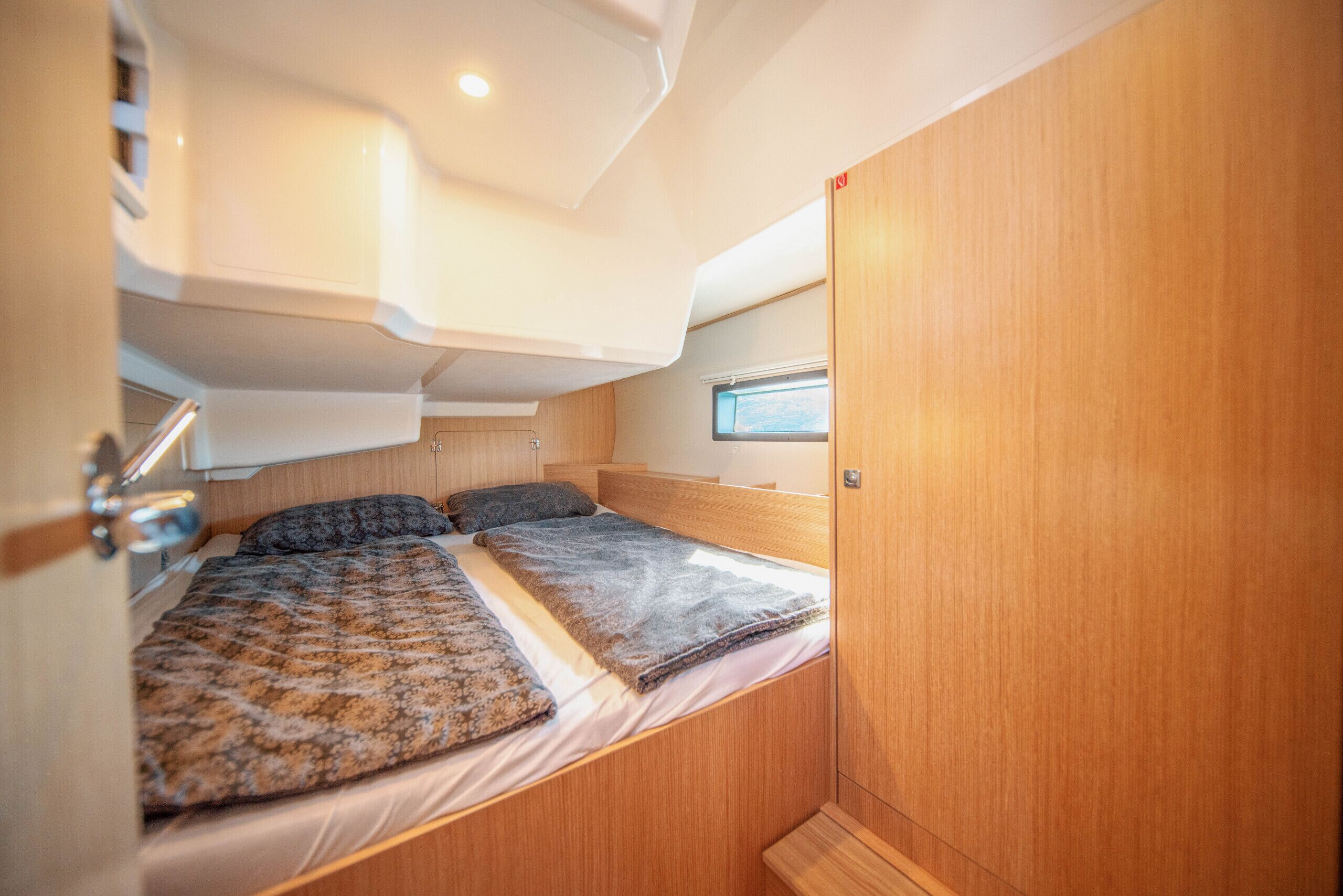 Un dormitorio pequeño con literas, una ventana y una puerta.