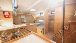 Een kleine keuken met een kookplaat, een eilandje en houten keukenkastjes.