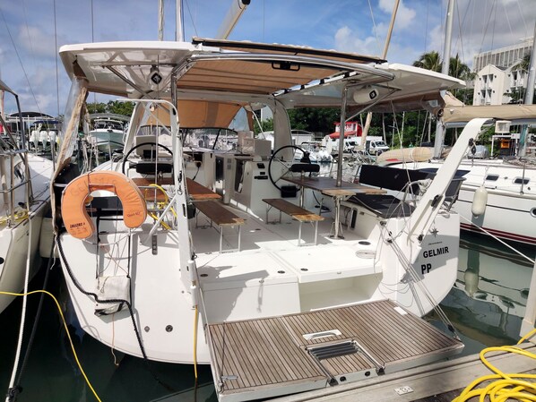 Un pont de bateau avec un espace salon, une bouée de sauvetage et une petite table.