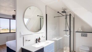 A modern bathroom with a glass-enclosed shower, a large mirror, and a white sink. - La Corniche - Belle maison pour 6 avec vue mer (Cancale)