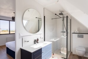 A modern bathroom with a glass-enclosed shower, a large mirror, and a white sink. - La Corniche - Belle maison pour 6 avec vue mer (Cancale)