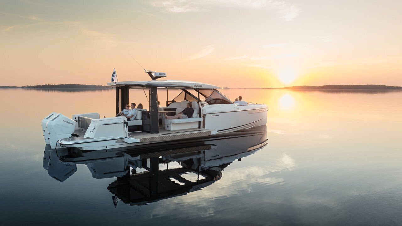 A boat with a covered deck, seating, and a steering wheel.