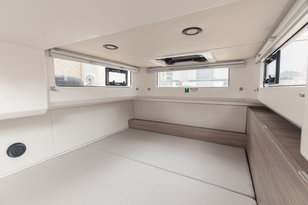 Un intérieur épuré et moderne, avec un banc, des fenêtres et un ventilateur de plafond.