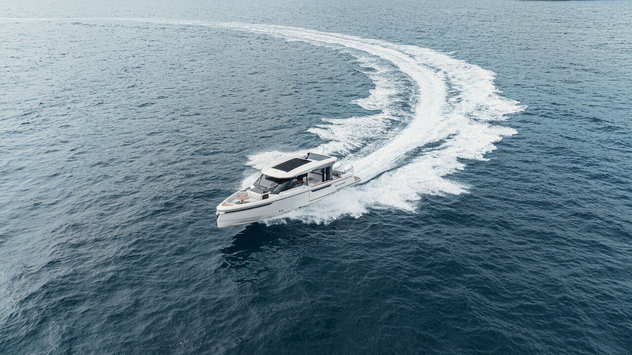 Un bateau navigue sur l’eau, laissant une vague derrière lui.