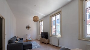 Una sala de estar moderna con un sofá, televisor y una mesa de comedor.