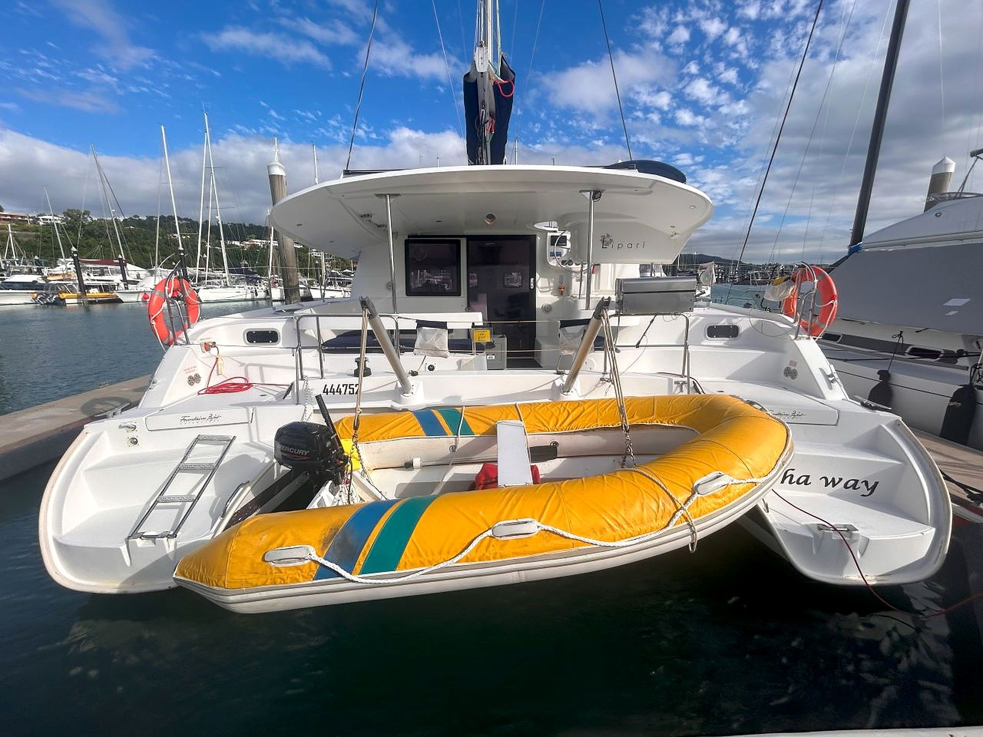 A boat with a yellow inflatable dinghy, a cabin, and a helipad.