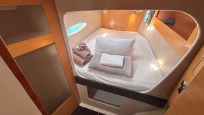 Una cabaña pequeña y luminosa, con una cama, una mesita y un ventanal.