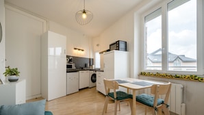 Eine moderne Küche mit Esstisch, Stühlen und Blick ins Freie.