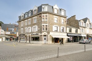 A corner building with multiple storefronts, including a bakery and a hair salon. - Le Studio du Val - 2min à pied de la plage (Pléneuf-Val-André)