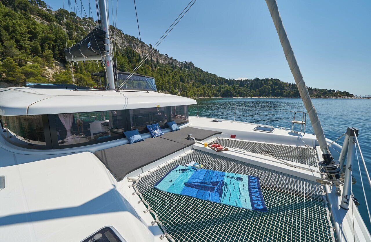A boat with a covered deck area, a seating arrangement, and a view of a mountainous coastline.