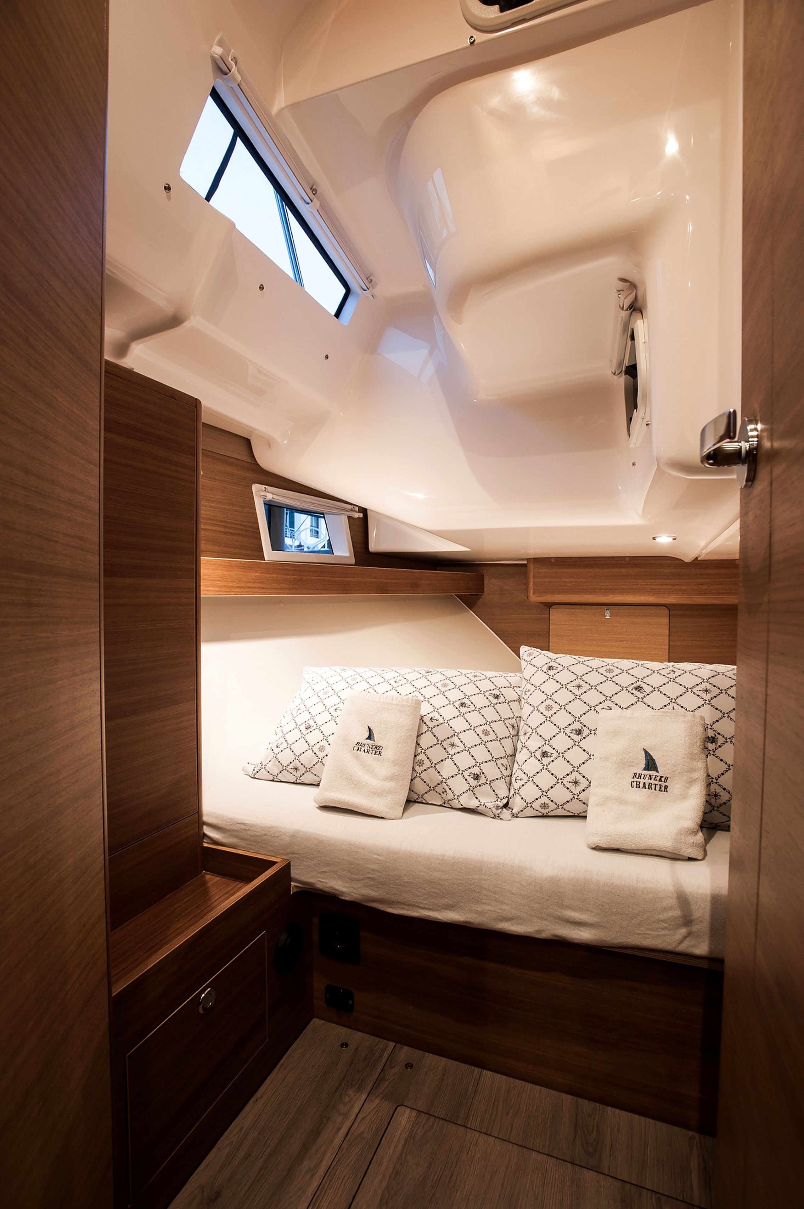 A compact cabin with a bed, a small window, and a built-in TV.