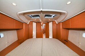 A narrow, elongated interior space with a central bed, wooden paneling, and two skylights. - Sun-Kissed Sailing Adventure in Zadar, Croatia (Zadar)