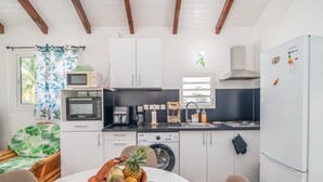 Una cucina compatta con forno a microonde, macchina da caffè e lavatrice.