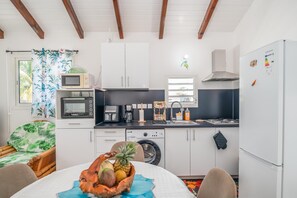 A compact kitchen with a microwave, coffee maker, and a washing machine. - L'Etoile des îles - À moins d'1 km de la plage (Sainte-Anne)