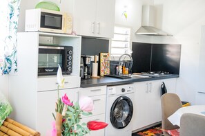A compact kitchen with a microwave, oven, toaster, sink, and washing machine. - L'Etoile des îles - À moins d'1 km de la plage (Sainte-Anne)