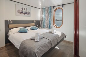 Ein Bett mit Kopfstück, Kissen, Decke und Handtuch.