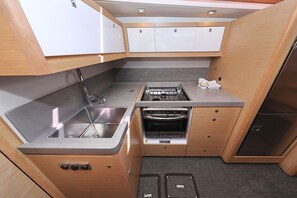 Una cocina compacta con fregadero, estufa, horno y alacenas.