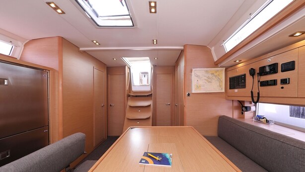 A compact interior with a central table, seating, a map on the wall, and a window. - Sun-Kissed Sailing Adventure in Zadar, Croatia (Biograd na moru)