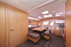 A compact RV interior with a kitchenette, a dining area, and a small seating space.