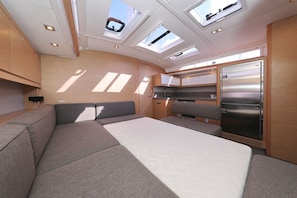 A compact interior with a bed, seating area, and a kitchenette.